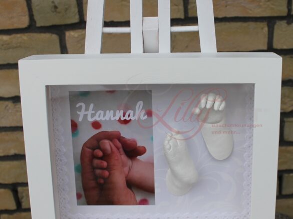 Hand und Fuß eines verstorbenen Babys(Sternenkind) in einem weißen Bilderrahmen